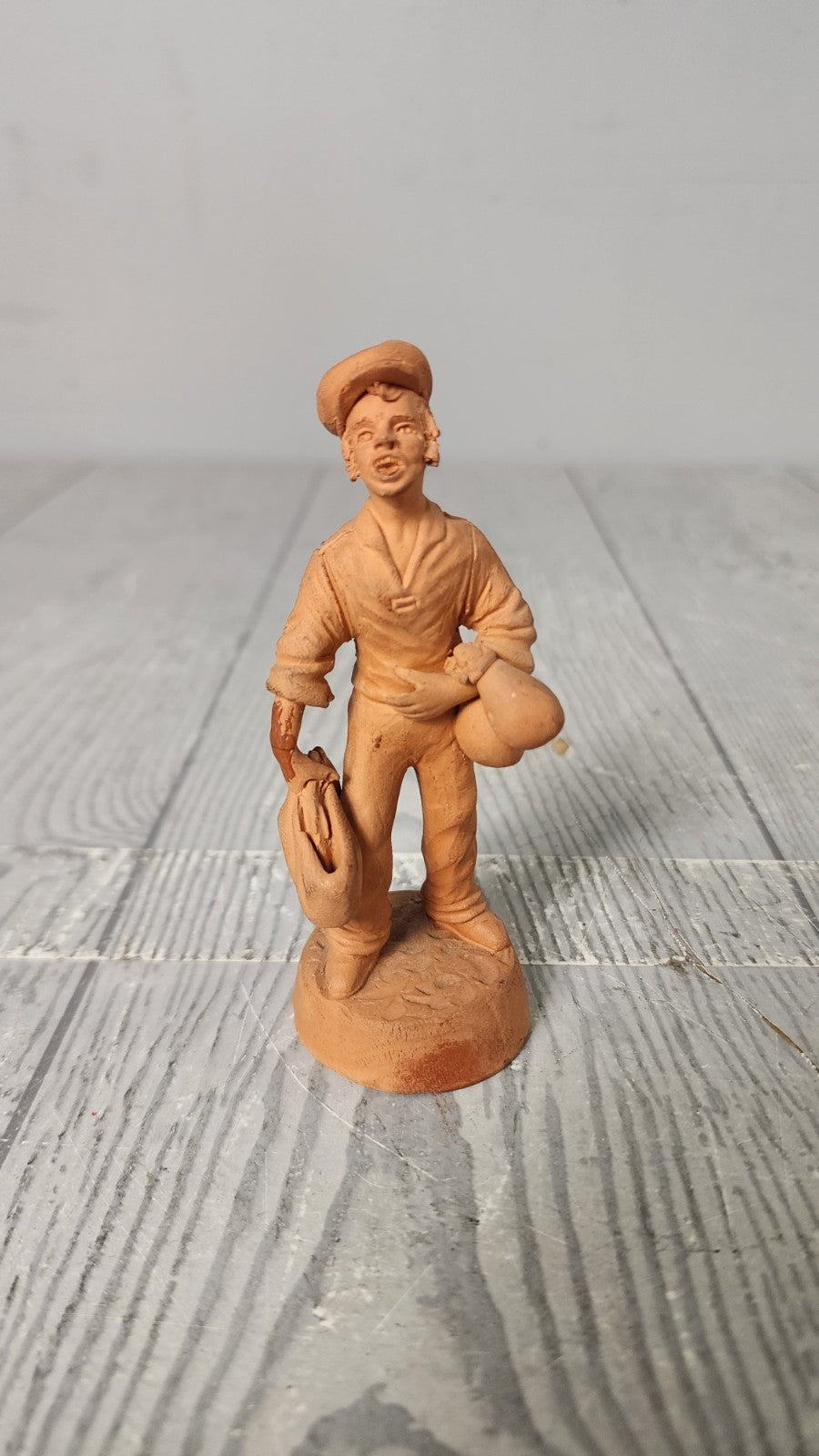 Vintage 5" Hand Made Terracotta Sculpture of a Man wt Bags in His Hands Unsigned